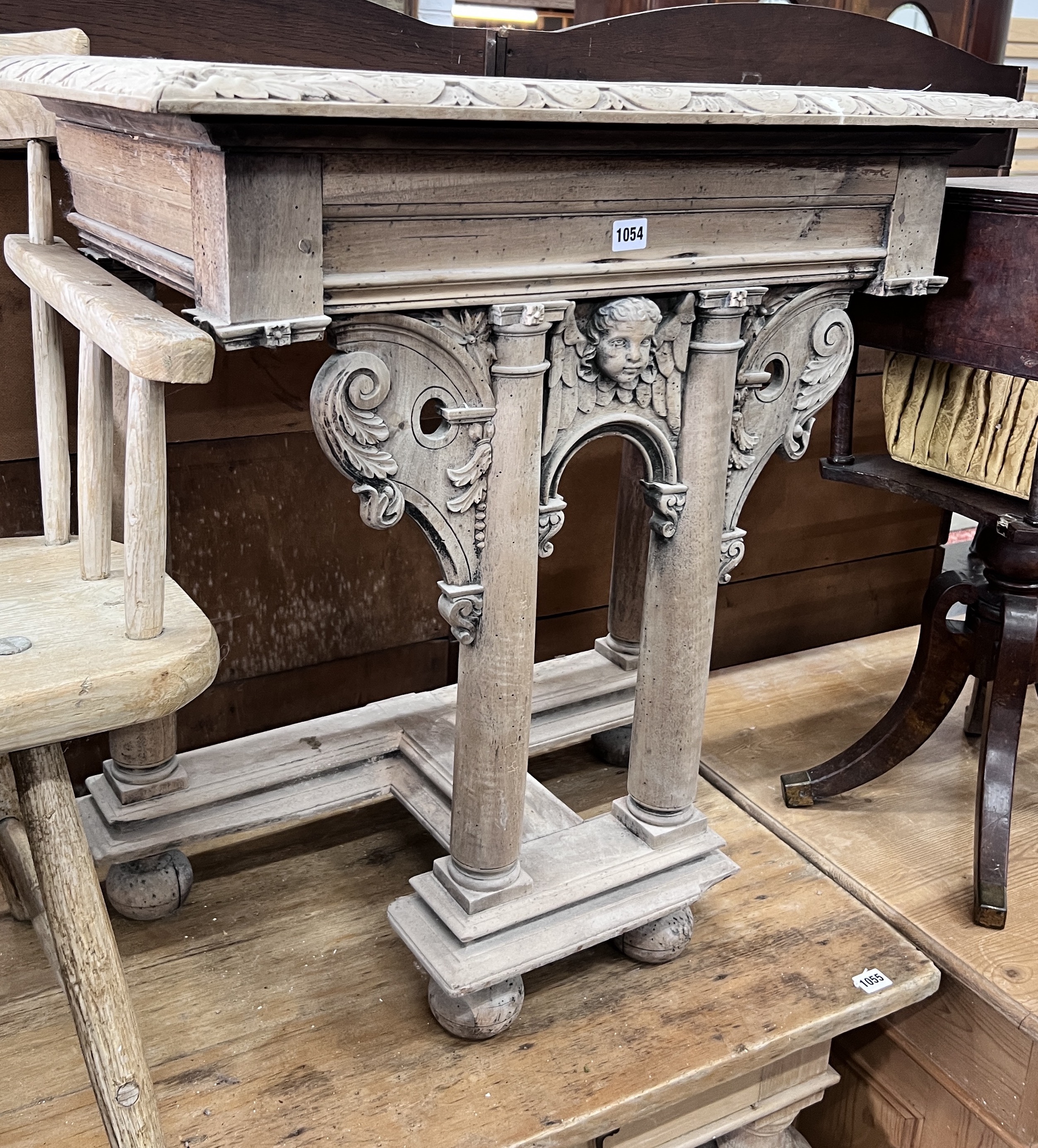 A limed carved pine table end, the top with a cut recess, width 78cm, depth 46cm, height 79cm